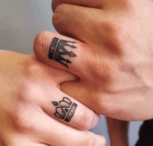 Couple's hands displaying matching crown tattoos, symbolizing love and commitment, featured in a blog about unique tattoo ideas for couples.